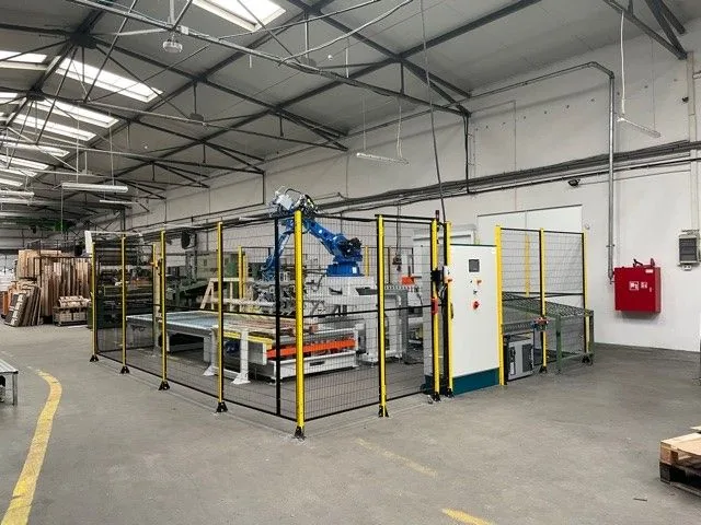 Robotic palletising cell with safety fencing installed on a production floor